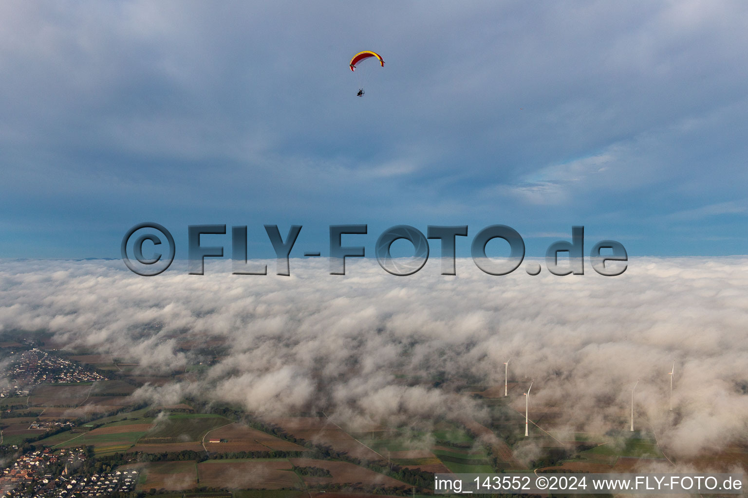 Paragleiter überm Windpark Freckenfeld in Wolken im Bundesland Rheinland-Pfalz, Deutschland