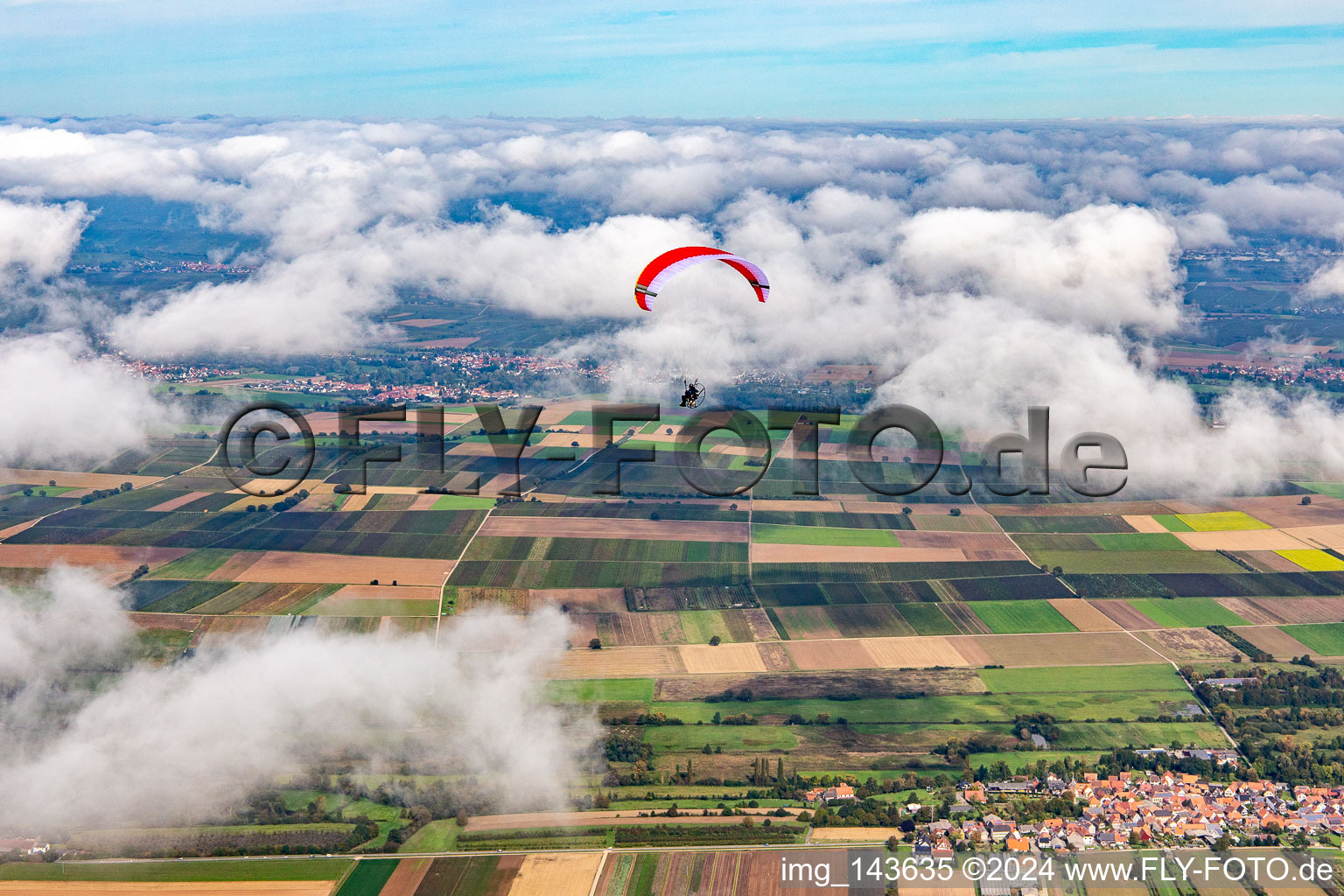 Paragleiter über dem Billigheimer Bruch in Wolken in Winden im Bundesland Rheinland-Pfalz, Deutschland