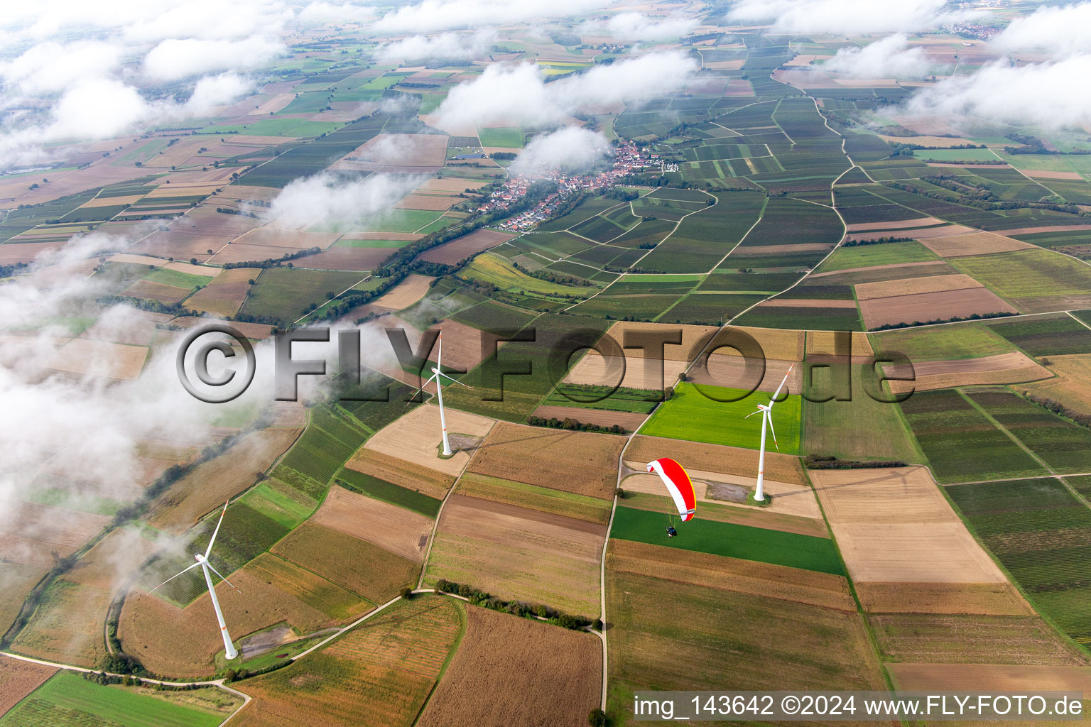 Luftbild von Paragleiter über dem Windpark Freckenfeld in Wolken im Bundesland Rheinland-Pfalz, Deutschland