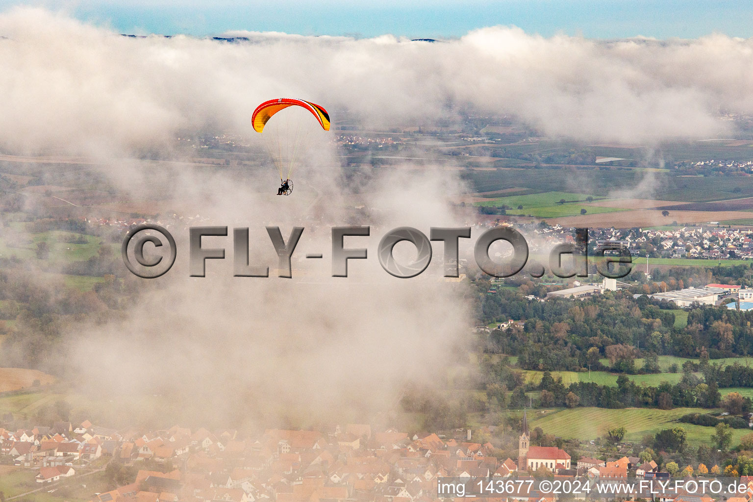 Ortschaft mit Gleitschirm unter herbstlichen Wolken in Steinweiler im Bundesland Rheinland-Pfalz, Deutschland