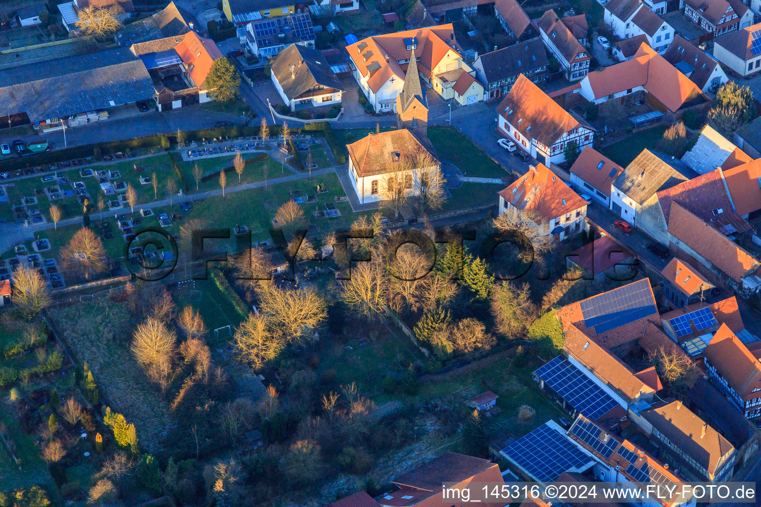 Protest. Kirche und Friedhof an einem Winterabend in Winden im Bundesland Rheinland-Pfalz, Deutschland