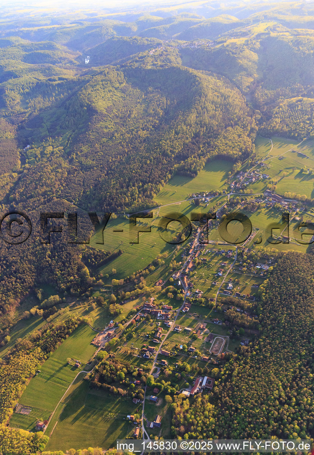 Dorfansicht in einer Waldlichtung der Nordvogesen aus Nordosten in Erckartswiller im Bundesland Bas-Rhin, Frankreich