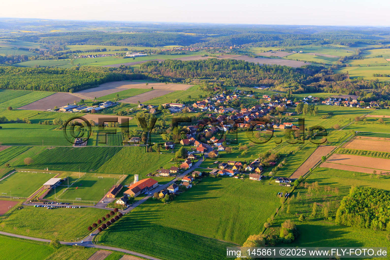 Dorfansicht aus Südwesten mit Sportplatz des ASI Avenir Football in Adamswiller im Bundesland Bas-Rhin, Frankreich