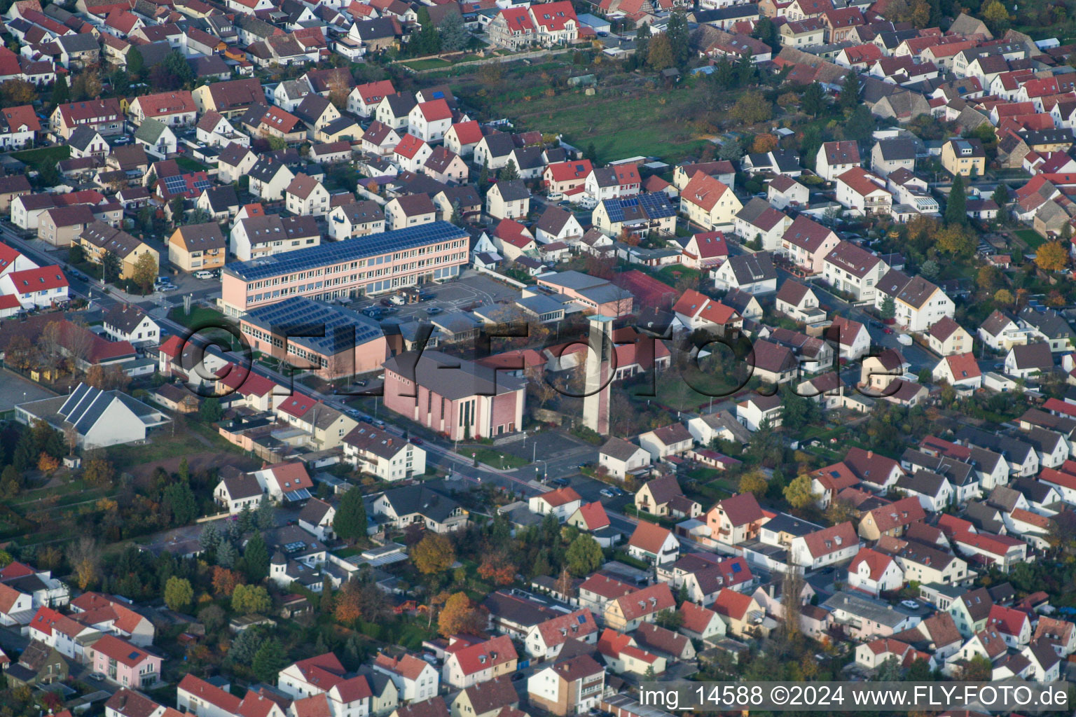 Schulgebäude der Ernst-Reuter Schule und Turm und Gotteshaus der St. Ulrich Kirche in Haßloch im Bundesland Rheinland-Pfalz, Deutschland