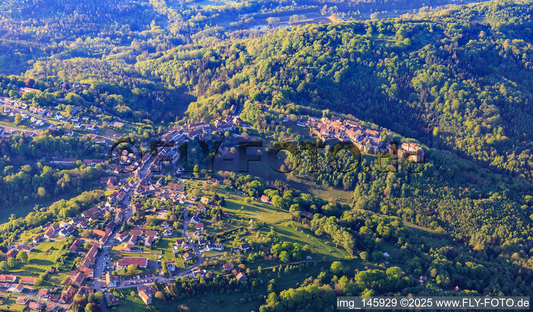 Luftaufnahme von Ortsansicht im buckligen Elsass der Nordvogesen mit Burg Lützelstein / Château de La Petite-Pierre am Morgen von Norden im Bundesland Bas-Rhin, Frankreich