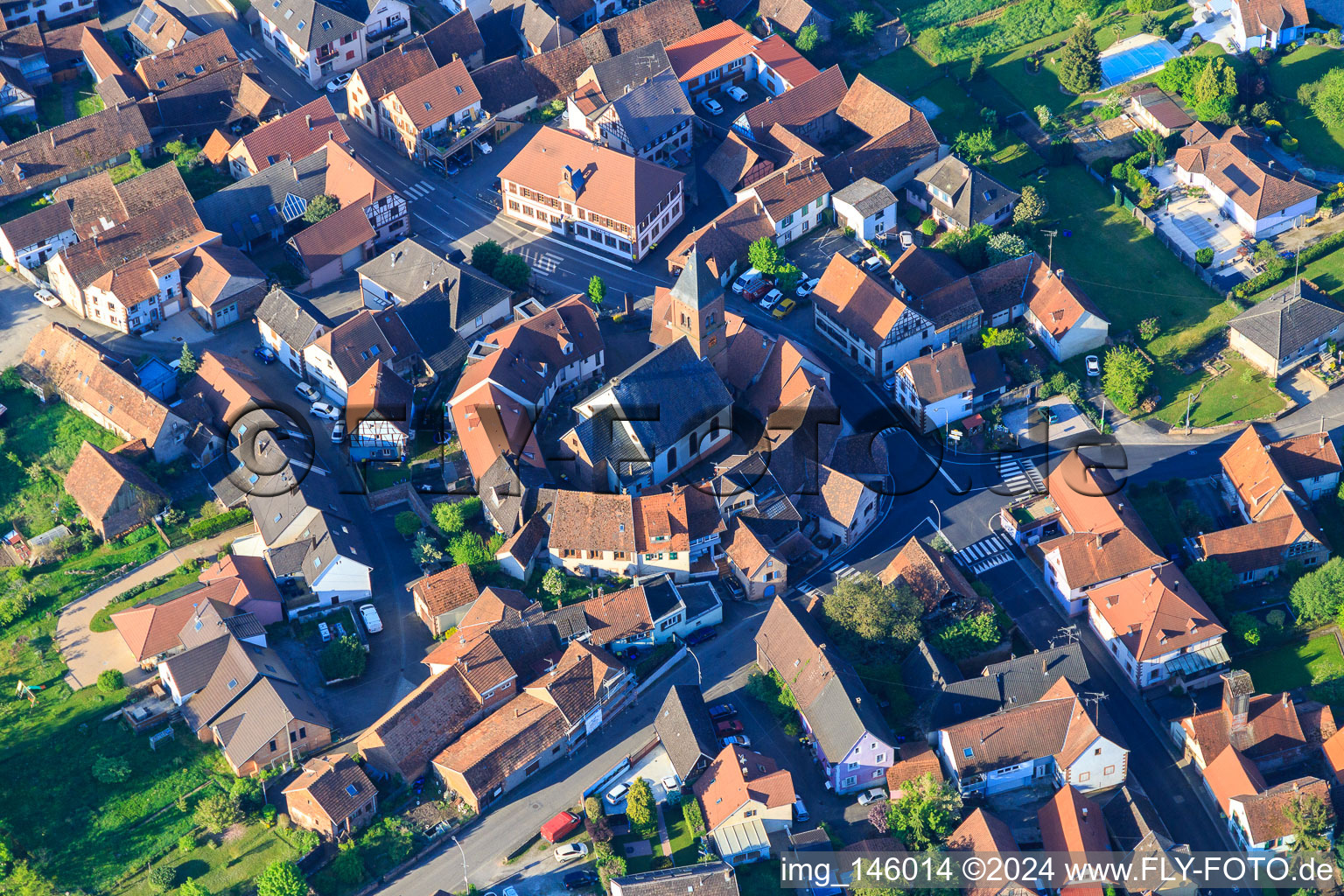 Schrägluftbild von Eglise protestante luthérienne als Wehrkirche von einem Kreis von Häußern umgeben in Dossenheim-sur-Zinsel im Bundesland Bas-Rhin, Frankreich