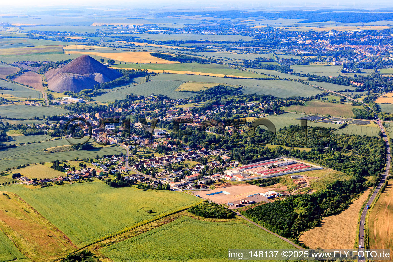 Dorfansicht vor der Halde "Fortschrittschacht" von Norden im Ortsteil Volkstedt in Eisleben im Bundesland Sachsen-Anhalt, Deutschland