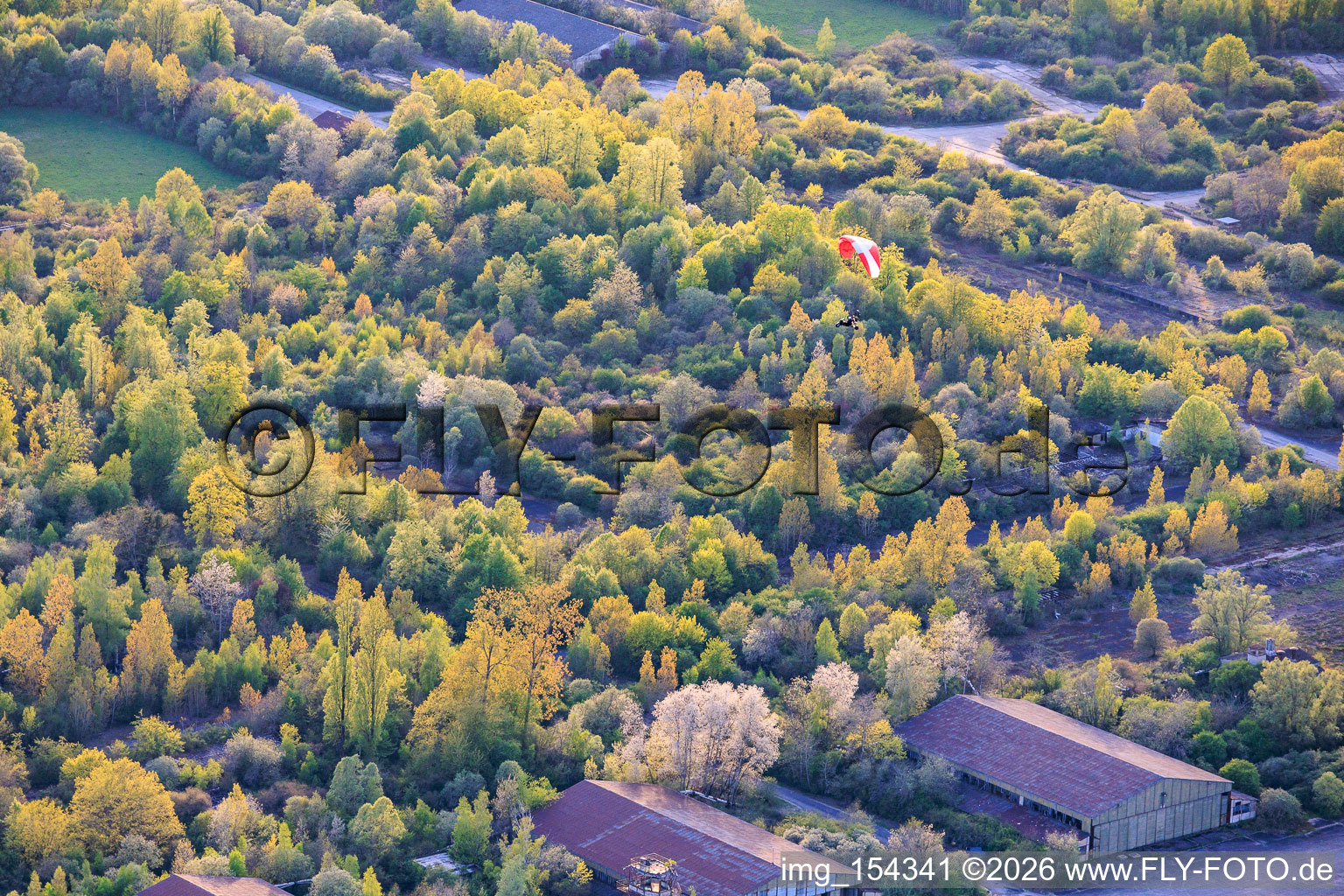 Paraglider über den Hangars am ehemaligen Miltärflugplatz Grostenquin in Bistroff im Bundesland Moselle, Frankreich