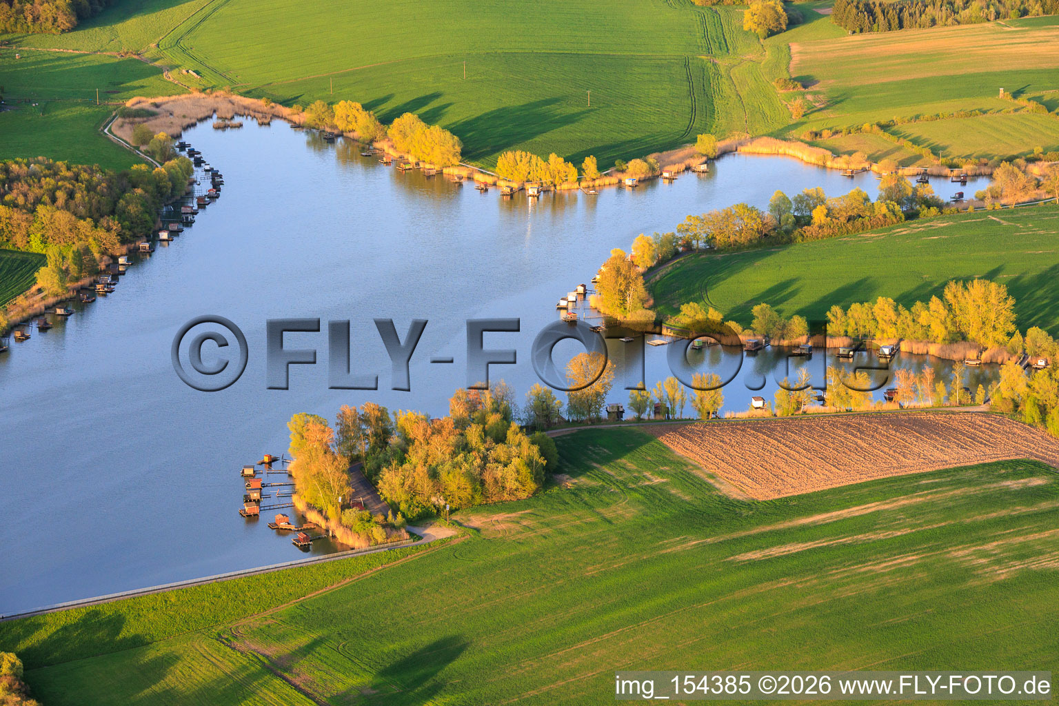 Stege mit Anglerhütten umsäumen das Ufer des Sees Etang du Welschhof in Puttelange-aux-Lacs im Bundesland Moselle, Frankreich
