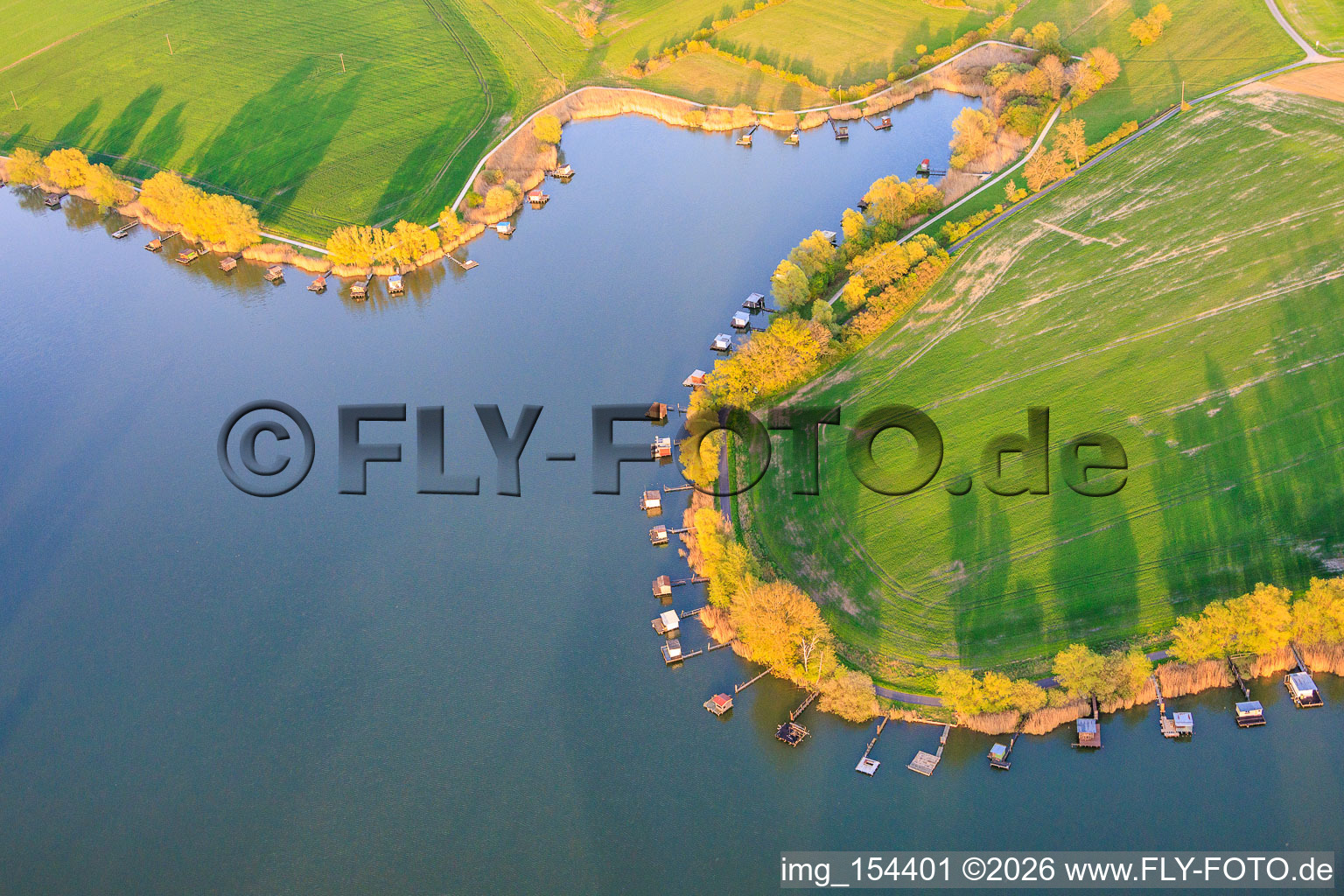 Stege mit Anglerhütten umsäumen das Ufer des Sees Etang du Welschhof in Puttelange-aux-Lacs im Bundesland Moselle, Frankreich
