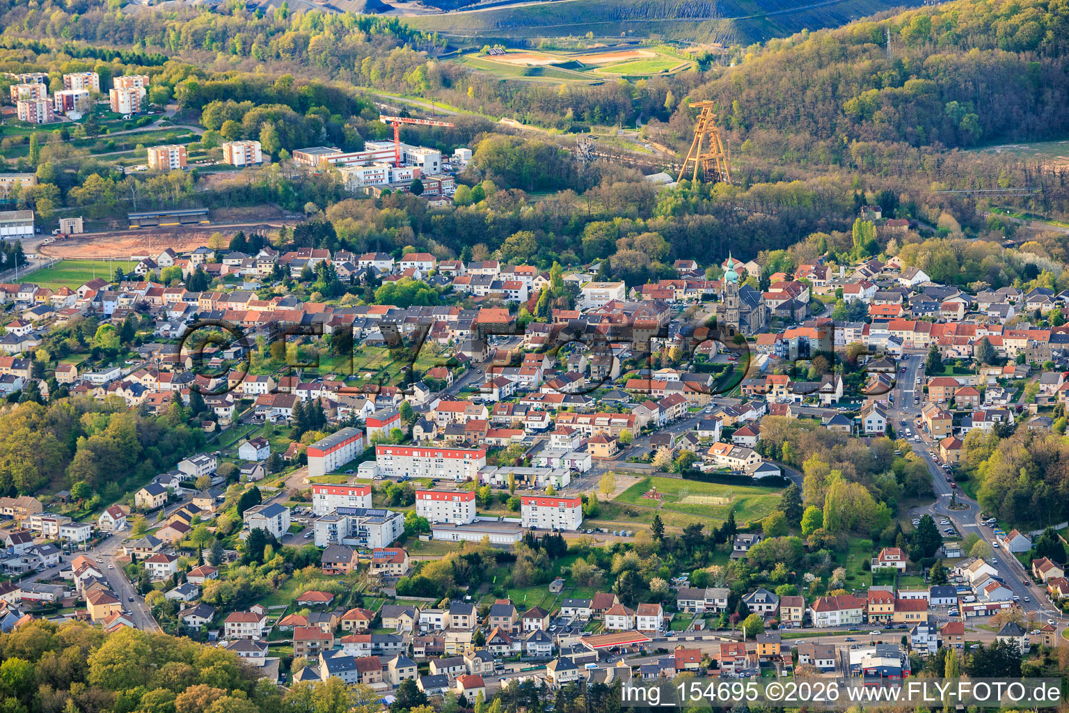 Stadtansicht von Süden vor dem historischen Berwerksförderturm Le puits Cuvelette Nord im Ortsteil Cité de la Chapelle in Freyming-Merlebach im Bundesland Moselle, Frankreich