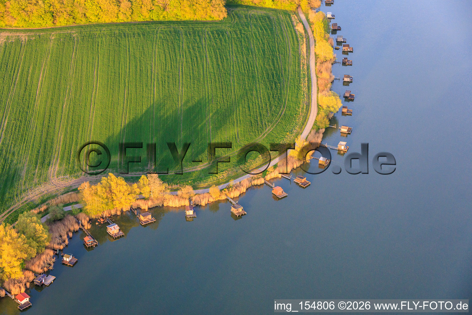 Stege mit Anglerhütten umsäumen das Ufer des Sees Etang du Welschhof in Puttelange-aux-Lacs im Bundesland Moselle, Frankreich