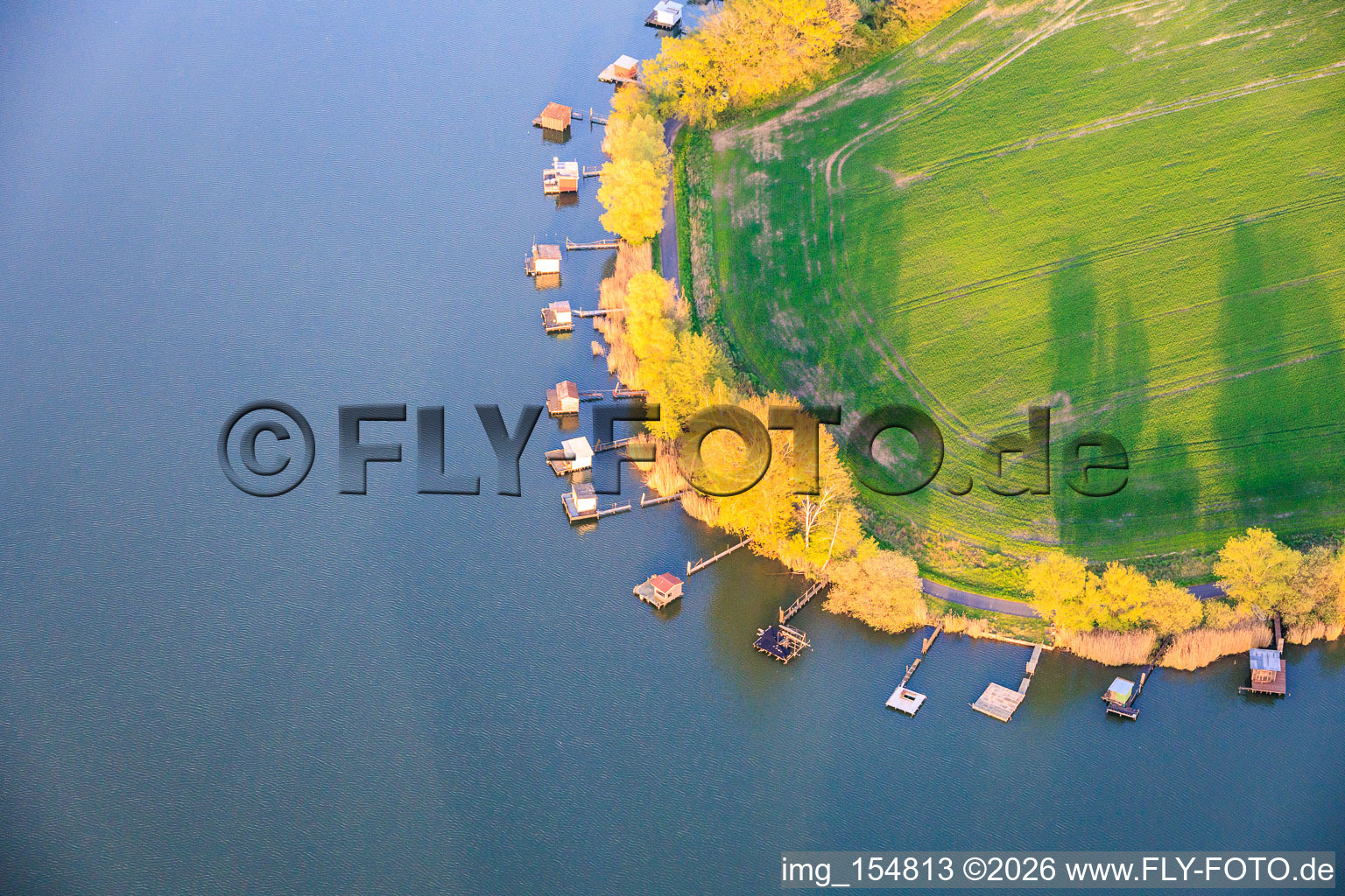 Stege mit Anglerhütten umsäumen das Ufer des Sees Etang du Welschhof in Puttelange-aux-Lacs im Bundesland Moselle, Frankreich