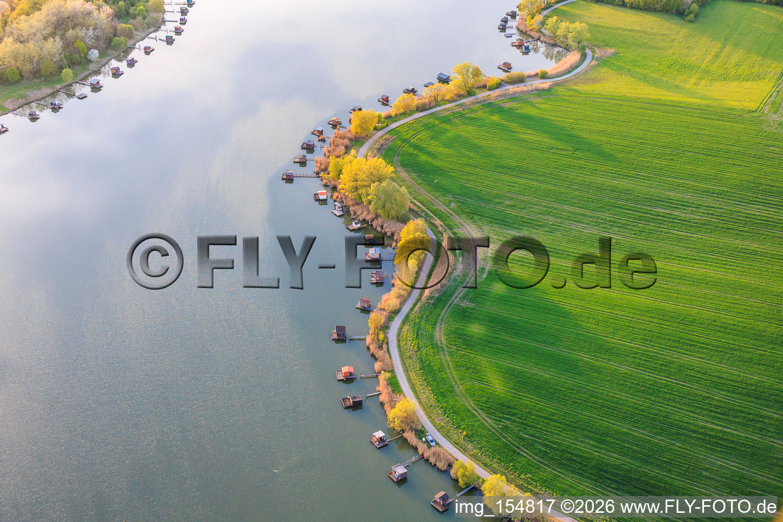 Stege mit Anglerhütten umsäumen das Ufer des Sees Etang du Welschhof in Puttelange-aux-Lacs im Bundesland Moselle, Frankreich
