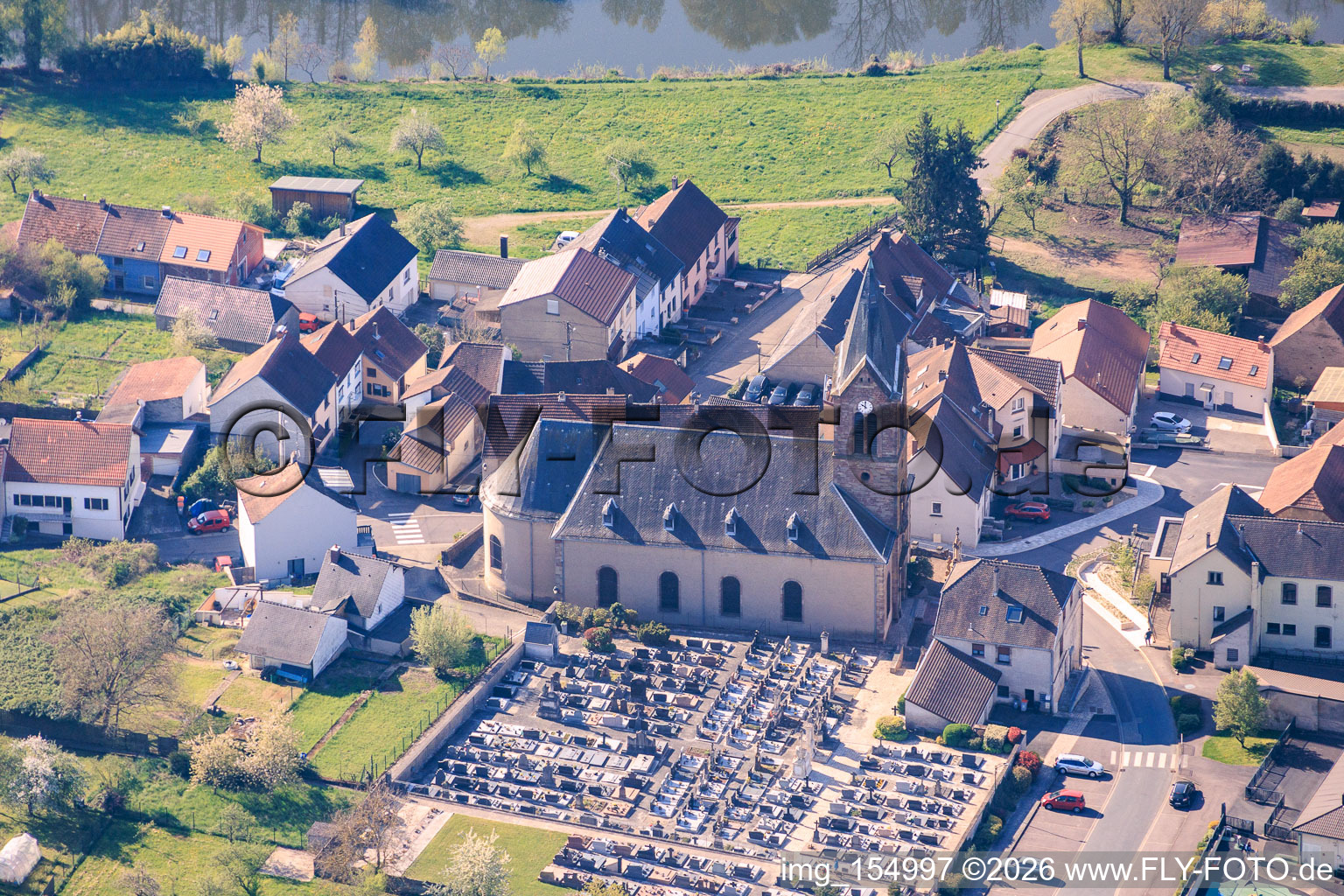 Kirche und Friedhof am Saarufer in Sarreinsming im Bundesland Moselle, Frankreich