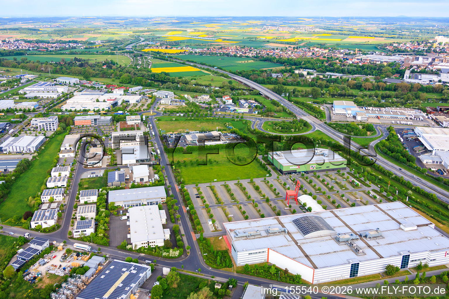 Gewerbegebiet Maintal mit rotem Riesenstuhl auf dem Parkplatz von XXXLutz Neubert Schweinfurt und mömax Schweinfurt im Ortsteil Oberndorf im Bundesland Bayern, Deutschland