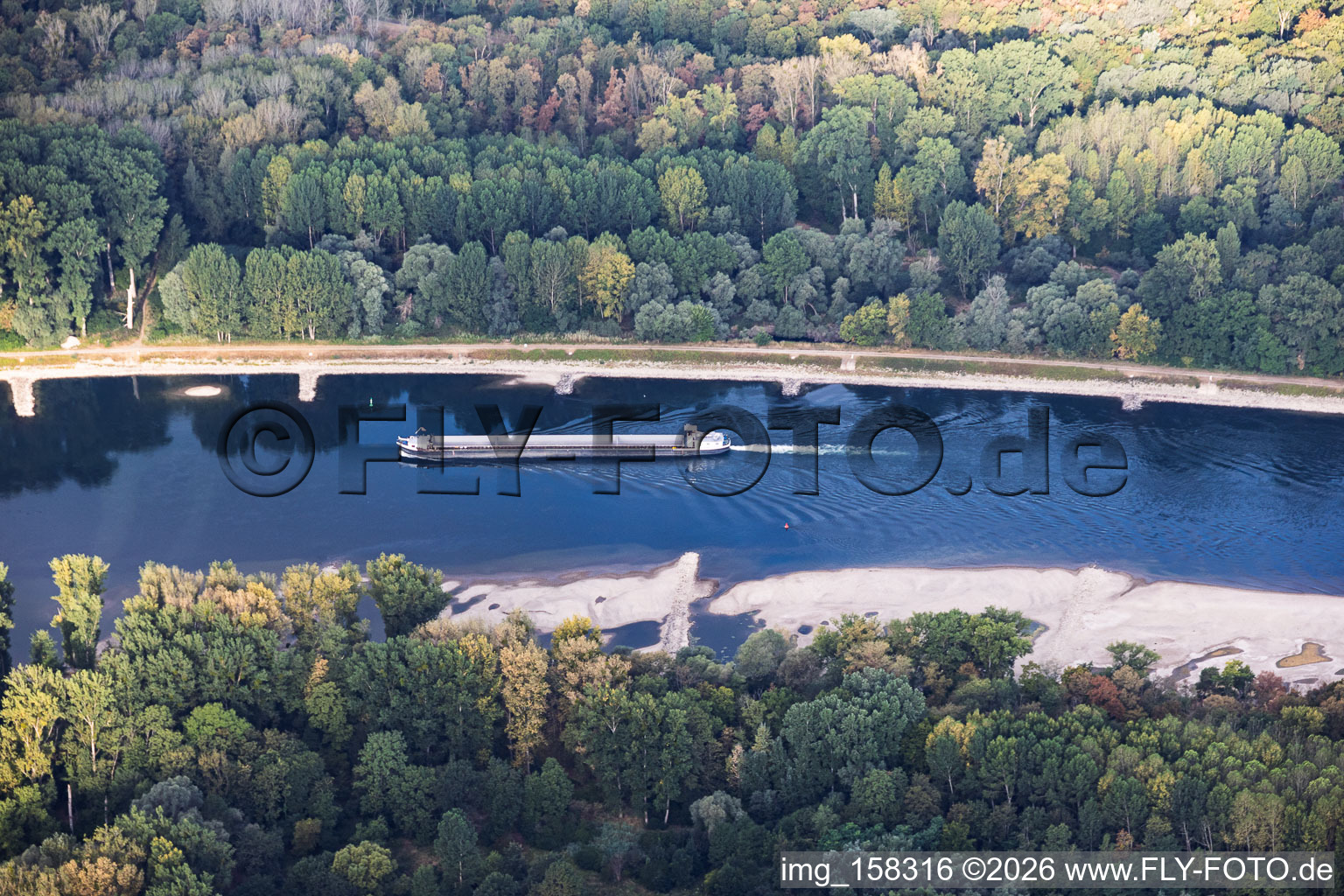 Leeres Frachtschiff bei Niedrigwasser am Rhein zwischen Hördter Rheinaue und Dettenheim im Ortsteil Liedolsheim im Bundesland Baden-Württemberg, Deutschland