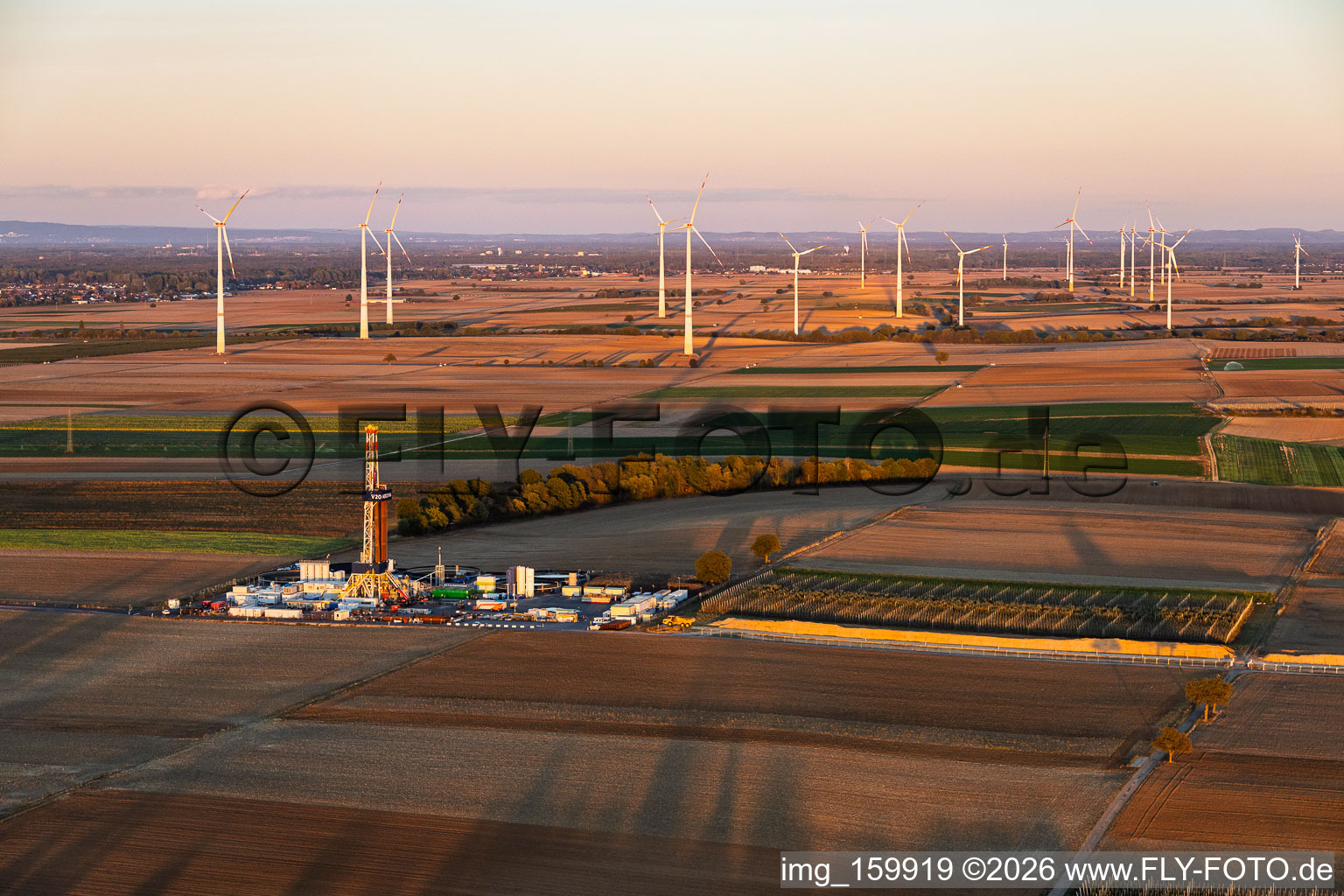 Tiefenbohrplatz Rig V20 - Vercana von Vulcan Energy vor dem Windpark Offenbach im Abendlicht am Schleidberg zur Förderung von Geothermie und Lithium in Insheim im Bundesland Rheinland-Pfalz, Deutschland
