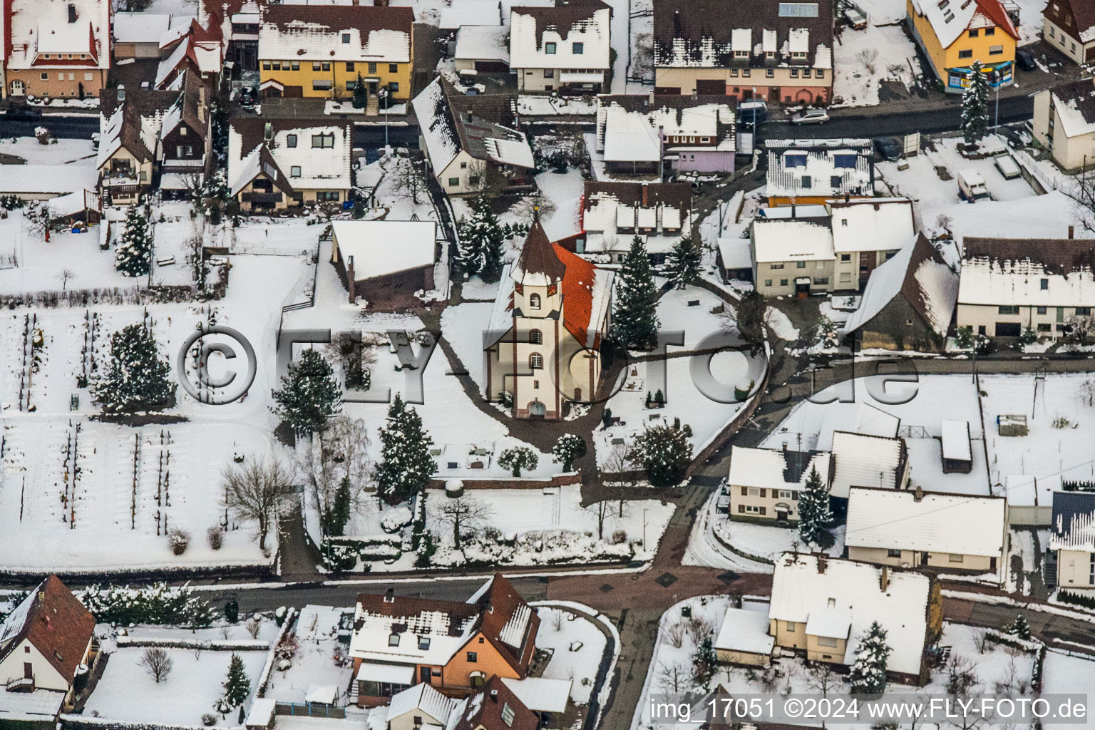 Winterlich schneebedeckte Kirchengebäude der Evangelischen Kirche in Ottenhausen in Straubenhardt im Bundesland Baden-Württemberg, Deutschland
