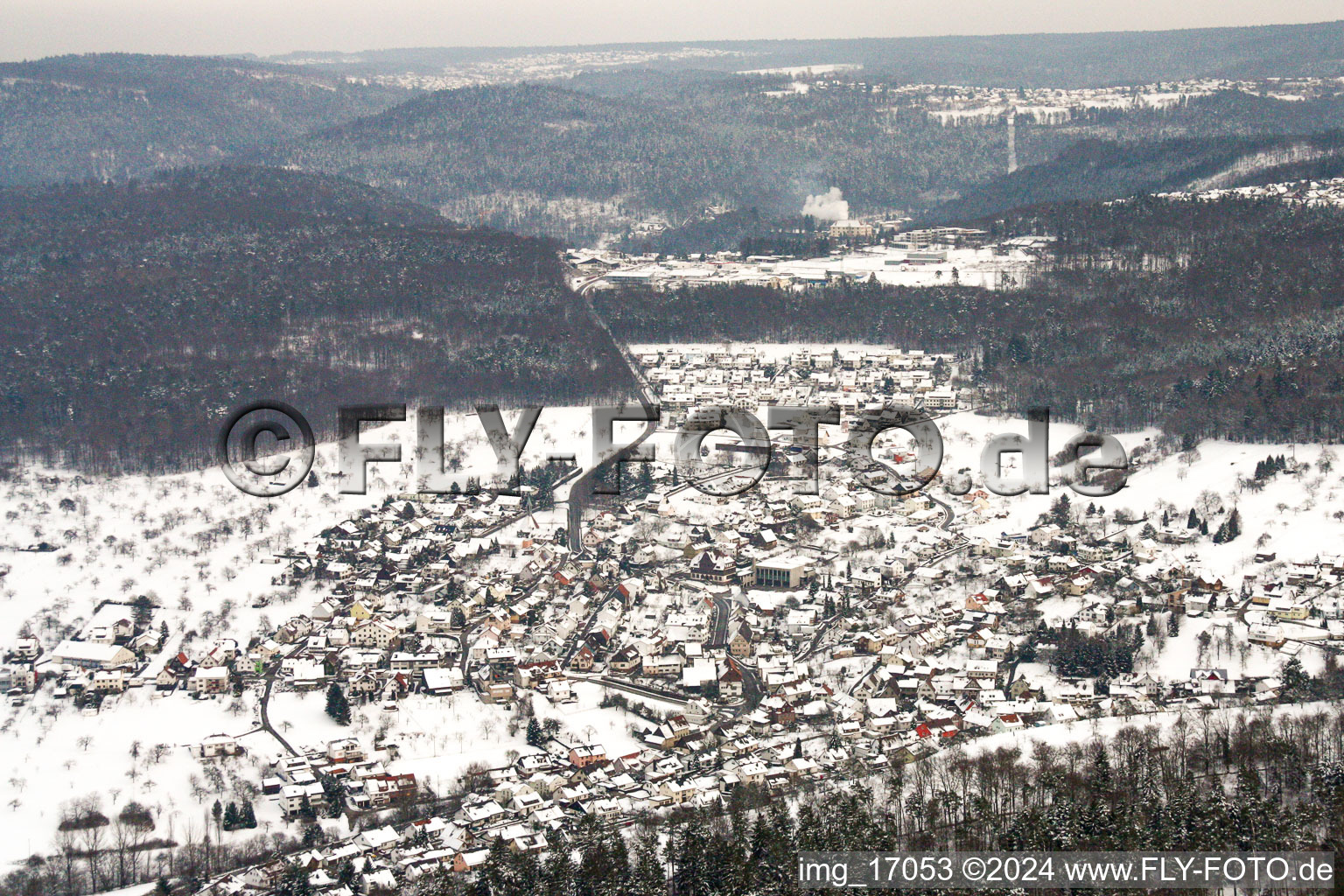 Winterlich schneebedeckte Dorf - Ansicht am Rande von landwirtschaftlichen Feldern und Nutzflächen in Birkenfeld im Bundesland Baden-Württemberg, Deutschland