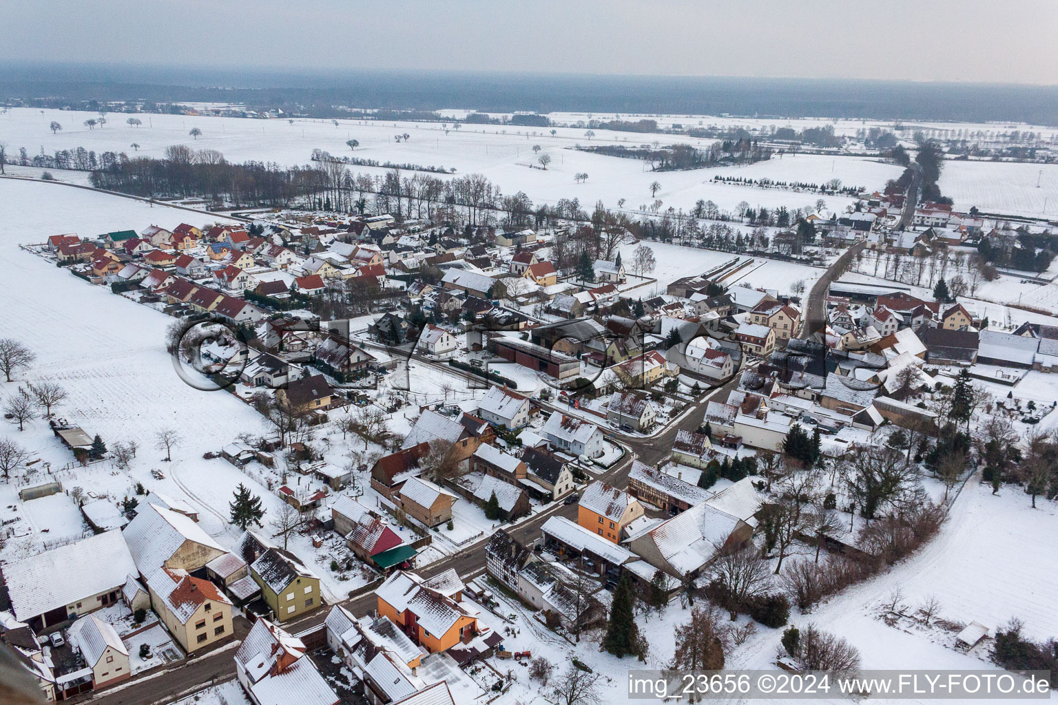 Winterlich schneebedeckte Dorf - Ansicht am Rande von landwirtschaftlichen Feldern und Nutzflächen im Ortsteil Kleinsteinfeld in Niederotterbach im Bundesland Rheinland-Pfalz, Deutschland