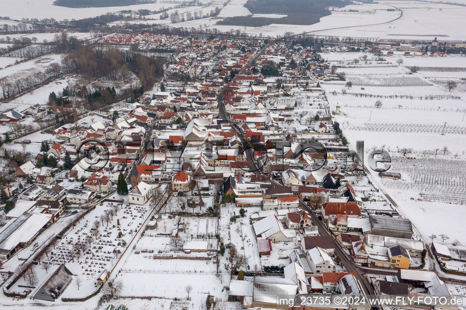 Winterlich schneebedeckte Dorf - Ansicht am Rande von landwirtschaftlichen Feldern und Nutzflächen in Winden im Bundesland Rheinland-Pfalz, Deutschland