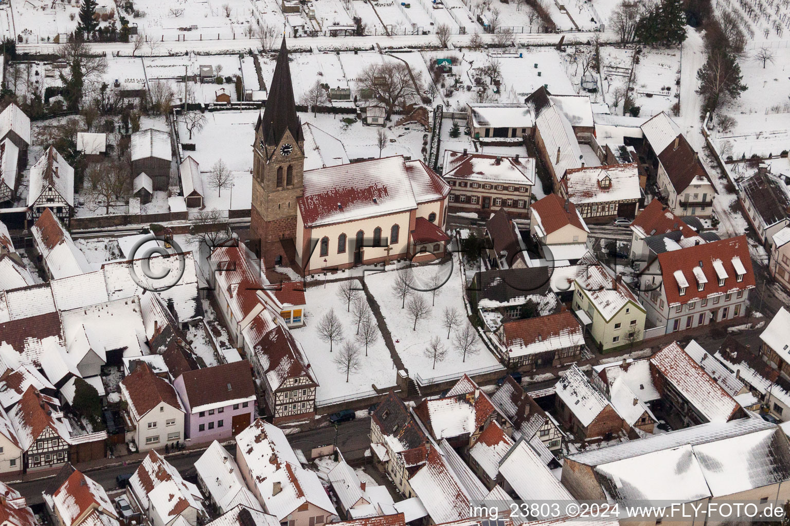 Luftbild von Winterlich schneebedeckte Kirchengebäude der katholischen Kirche in der Dorfmitte in Steinweiler im Bundesland Rheinland-Pfalz, Deutschland