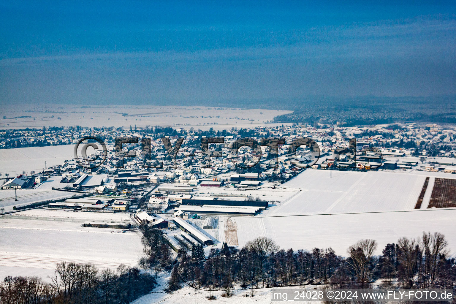 Winterlich schneebedeckte Dorf - Ansicht am Rande von landwirtschaftlichen Feldern und Nutzflächen in Rheinzabern im Bundesland Rheinland-Pfalz, Deutschland