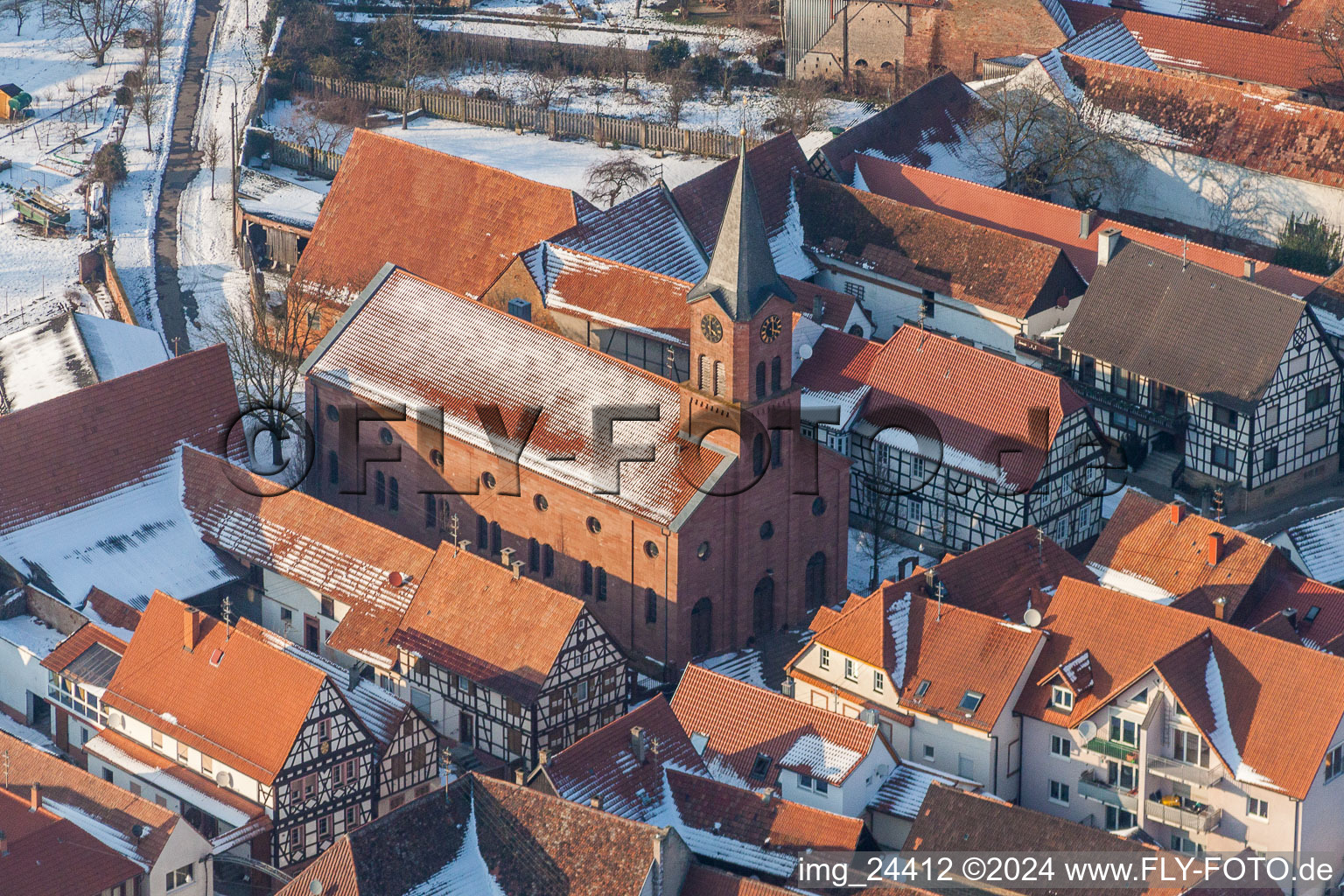 Luftbild von Winterlich schneebedeckte Kirchengebäude der evangelischen Kirche in der Dorfmitte in Steinweiler im Bundesland Rheinland-Pfalz, Deutschland