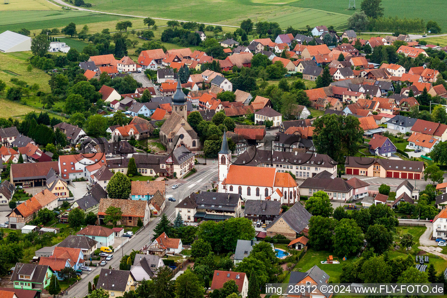Luftbild von Kirchengebäude der beiden Kirchen Eglise Evangélique et Catholique in der Dorfmitte in Stattmatten in Grand Est im Bundesland Bas-Rhin, Frankreich