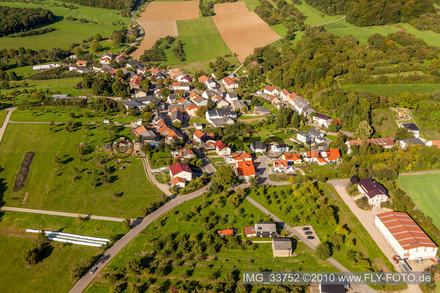 Dorf - Ansicht am Rande von landwirtschaftlichen Feldern und Nutzflächen in Wochern im Bundesland Saarland, Deutschland