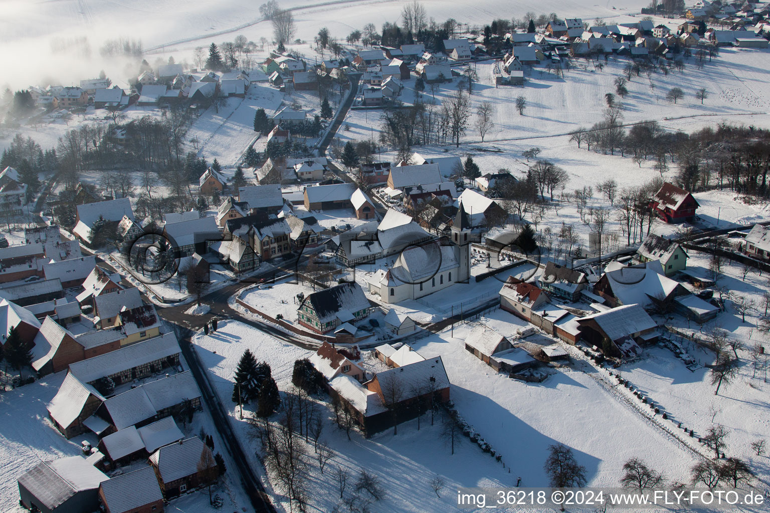 Luftbild von Winterlich schneebedeckte Kirchengebäude im Dorfkern in Eberbach-Seltz in Grand Est im Bundesland Bas-Rhin, Frankreich