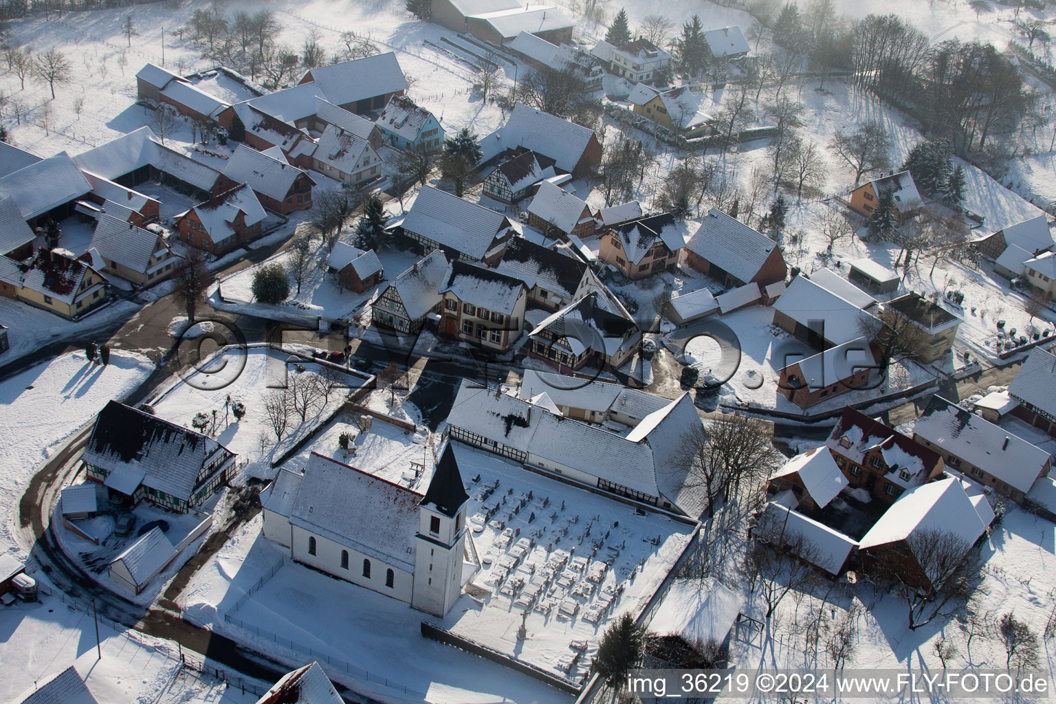 Luftaufnahme von Winterlich schneebedeckte Kirchengebäude im Dorfkern in Eberbach-Seltz in Grand Est im Bundesland Bas-Rhin, Frankreich