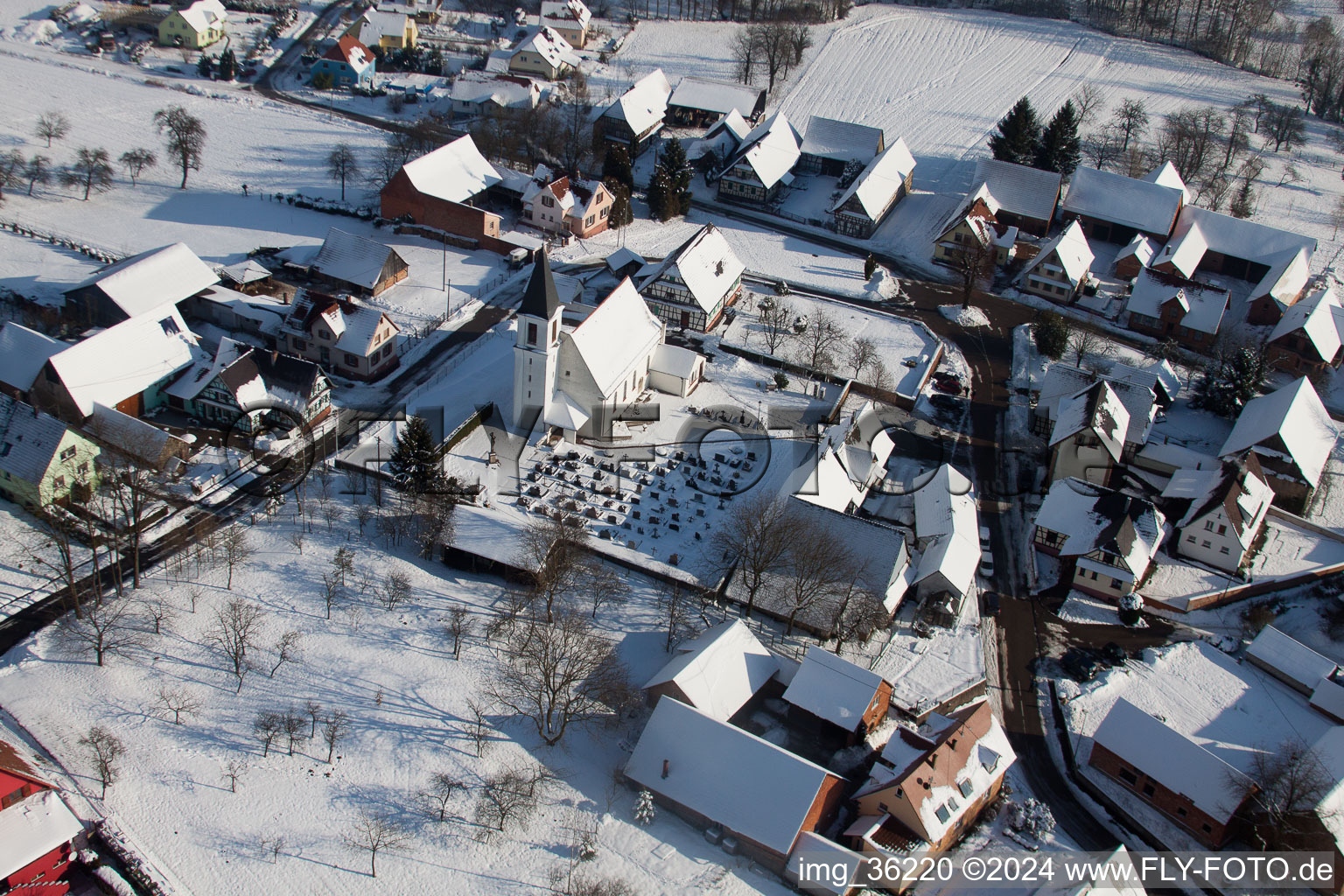 Schrägluftbild von Winterlich schneebedeckte Kirchengebäude im Dorfkern in Eberbach-Seltz in Grand Est im Bundesland Bas-Rhin, Frankreich