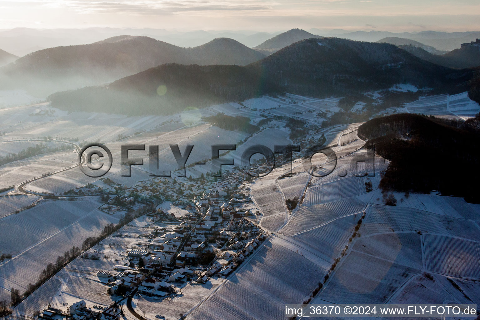 Luftaufnahme von Winterlich schneebedeckte Dorf - Ansicht am Rande von beschneiten Weinbergen in Ranschbach im Bundesland Rheinland-Pfalz, Deutschland