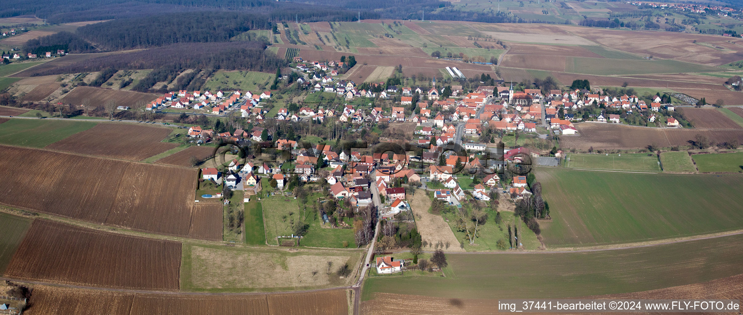 Dorf - Ansicht am Rande von landwirtschaftlichen Feldern und Nutzflächen in Kutzenhausen in Grand Est im Bundesland Bas-Rhin, Frankreich