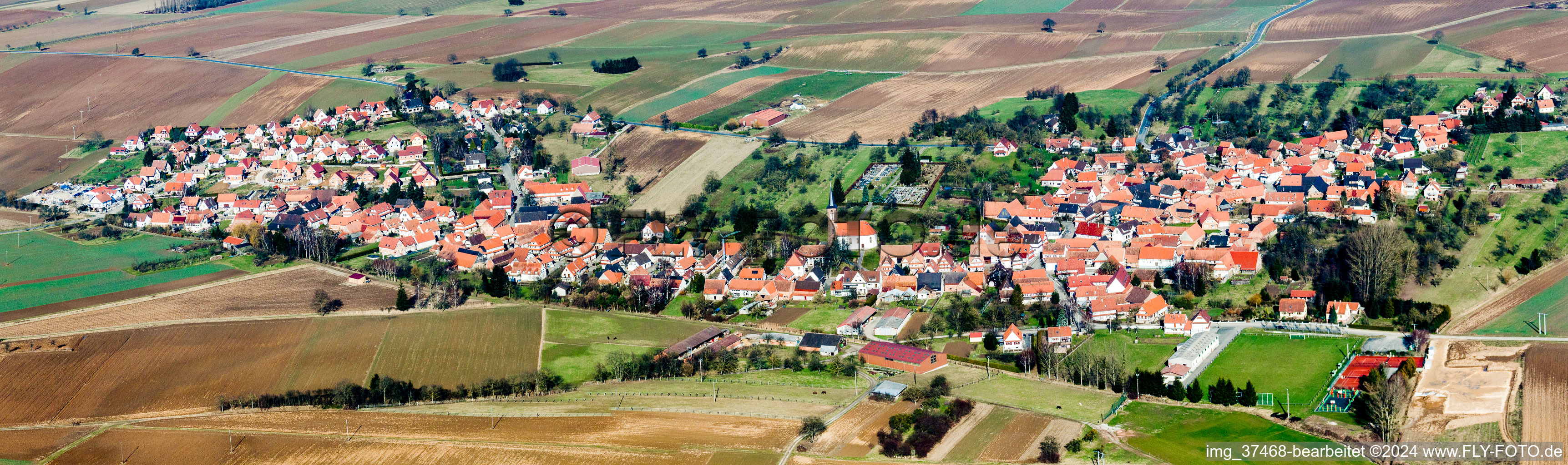 Panorama der Dorf - Ansicht am Rande von landwirtschaftlichen Feldern und Nutzflächen in Hunspach in Grand Est im Bundesland Bas-Rhin, Frankreich