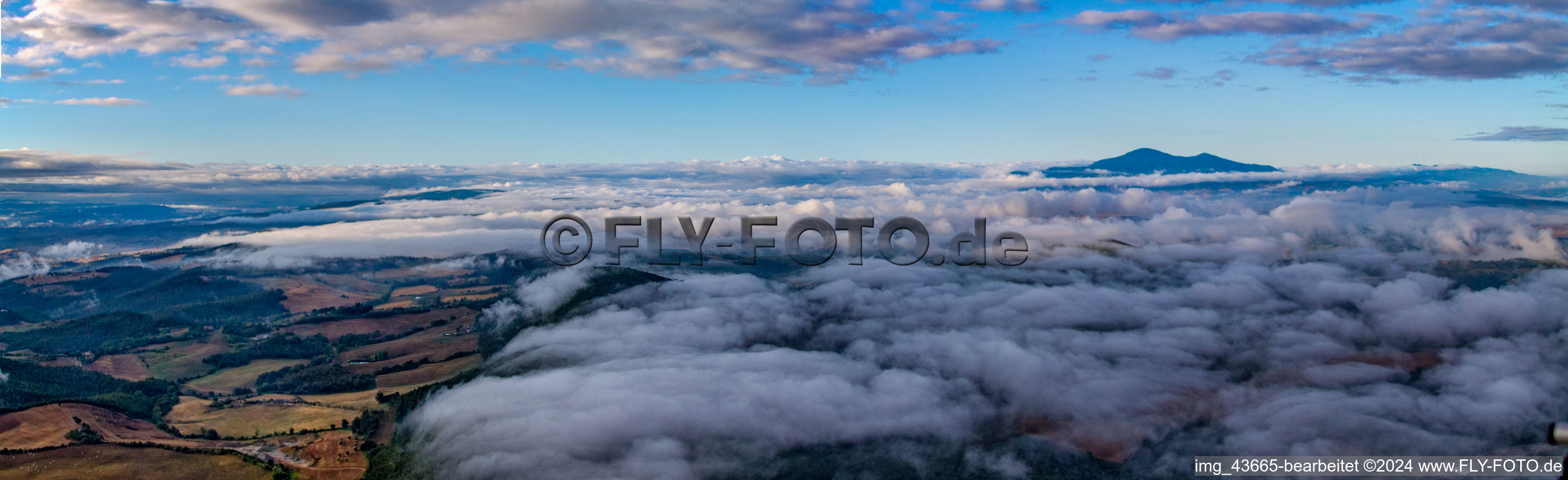 Panorama des Sonnenaufgang über Wolken und der Landschaft mit Gleitschirmpiloten in Montepulciano in Toscana, Italien