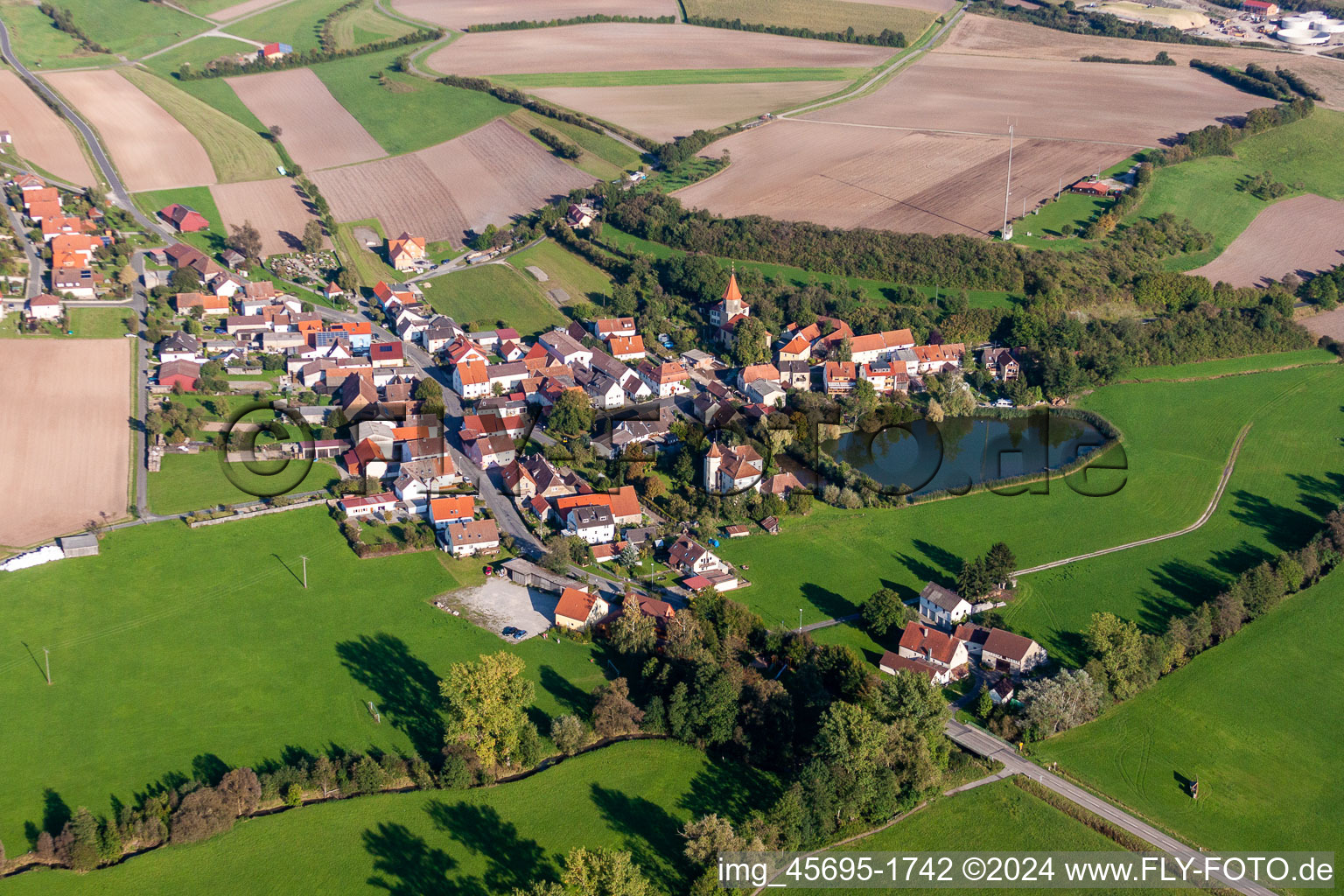 Dorf - Ansicht am Rande von landwirtschaftlichen Feldern und Nutzflächen im Ortsteil Schnodsenbach in Scheinfeld im Bundesland Bayern, Deutschland