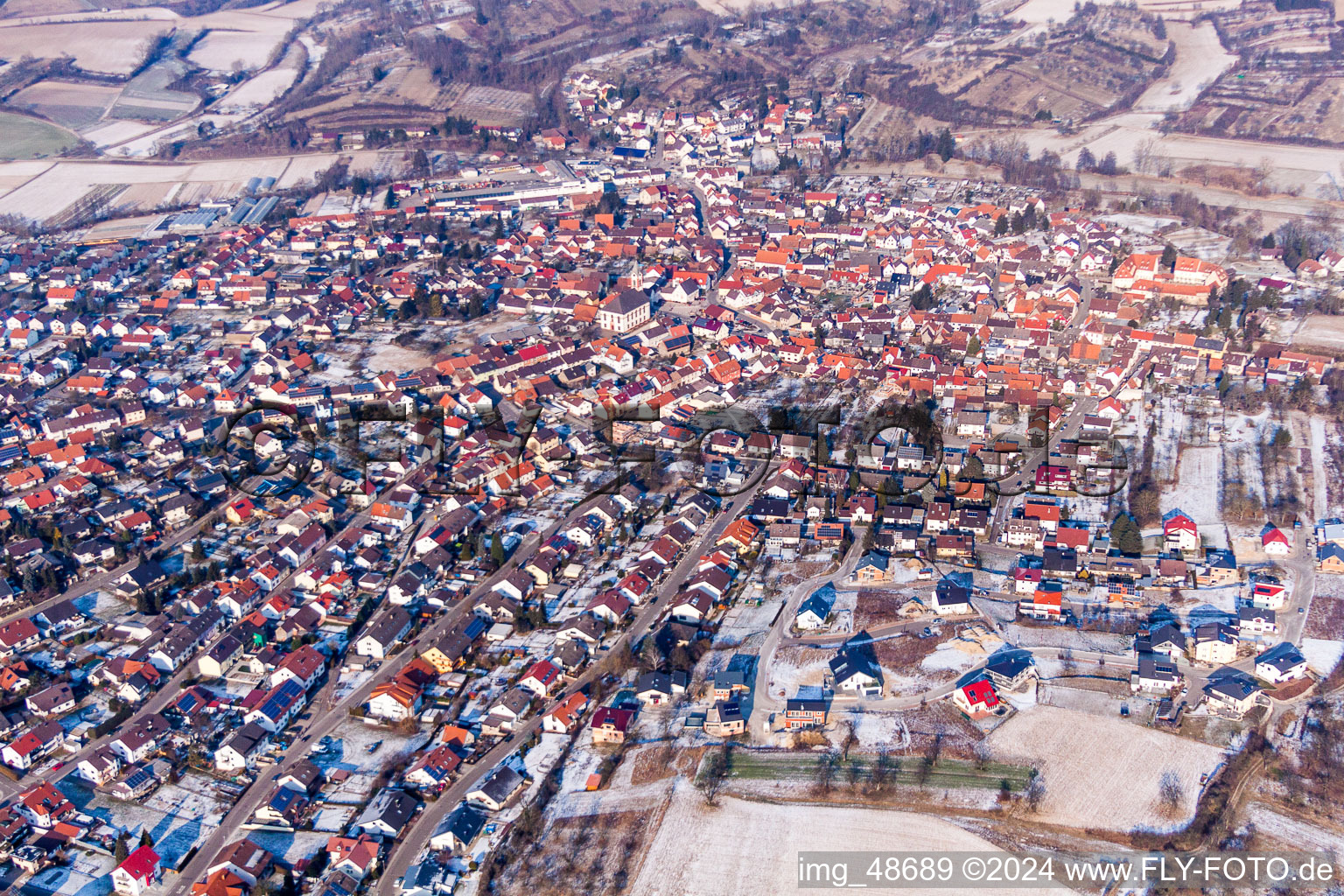 Winterlich schneebedeckte Ortsansicht der Straßen und Häuser der Wohngebiete in Unteröwisheim in Kraichtal im Bundesland Baden-Württemberg, Deutschland