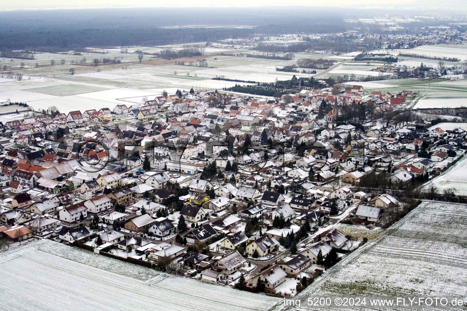 Winterlich schneebedeckte Dorf - Ansicht am Rande von landwirtschaftlichen Feldern und Nutzflächen in Freckenfeld im Bundesland Rheinland-Pfalz, Deutschland