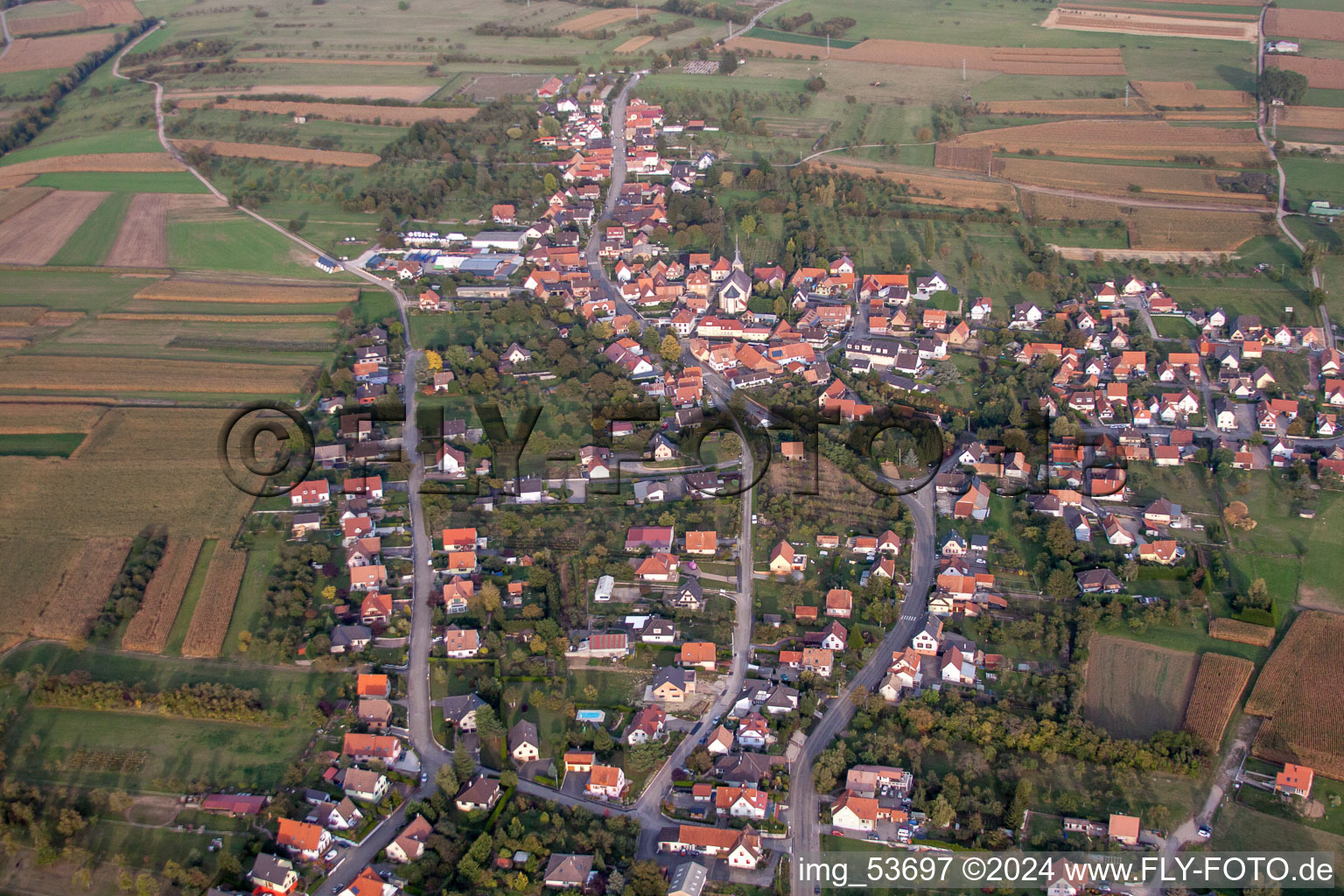 Schrägluftbild von Dorf - Ansicht am Rande von landwirtschaftlichen Feldern und Nutzflächen in Gunstett in Grand Est im Bundesland Bas-Rhin, Frankreich