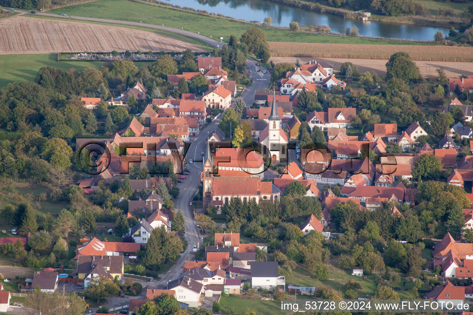 Luftbild von Kirchengebäude im Dorfkern in Kutzenhausen in Grand Est im Bundesland Bas-Rhin, Frankreich