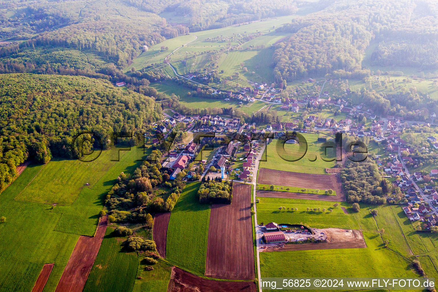 Dorf - Ansicht am Rande von landwirtschaftlichen Feldern und Nutzflächen in Langensoultzbach in Grand Est im Bundesland Bas-Rhin, Frankreich