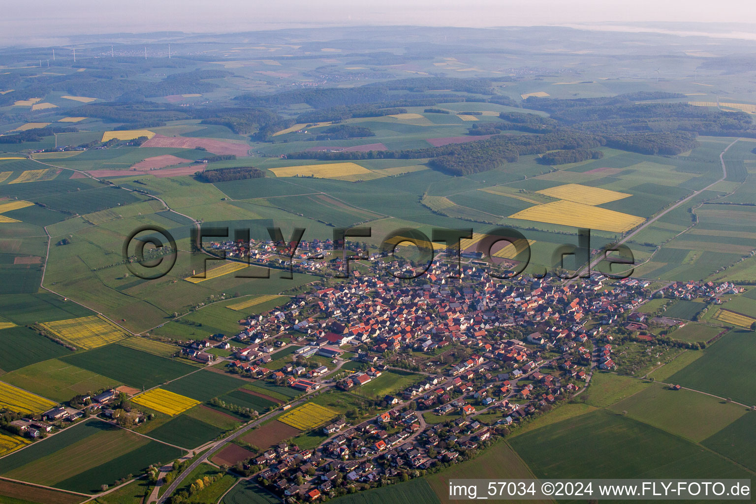 Dorf - Ansicht am Rande von landwirtschaftlichen Feldern und Nutzflächen in Kleinrinderfeld im Bundesland Bayern, Deutschland
