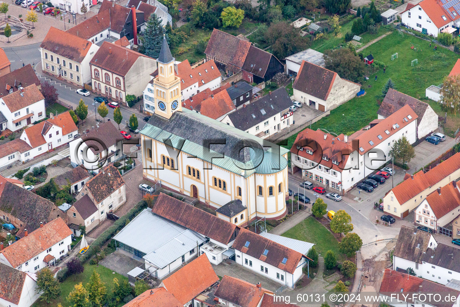 Schrägluftbild von Kirchengebäude im Dorfkern in Lingenfeld im Bundesland Rheinland-Pfalz, Deutschland