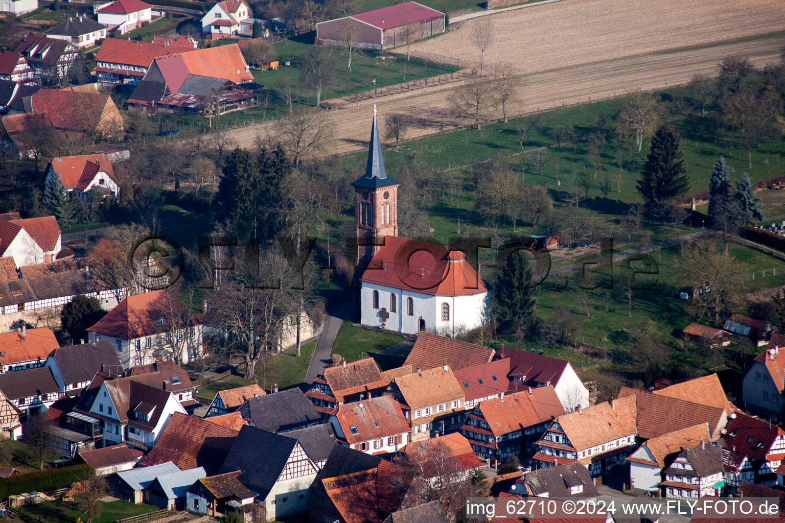 Luftbild von Kirchengebäude der  Église Protestante de Hunspach im Dorfkern in Hunspach in Grand Est im Bundesland Bas-Rhin, Frankreich