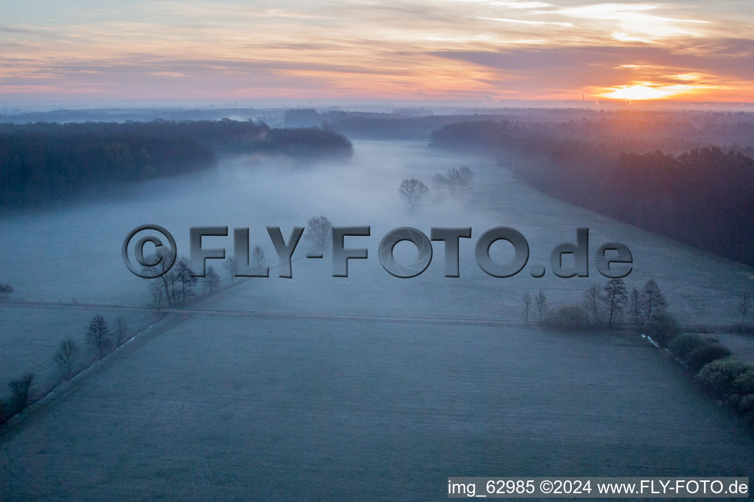 Morgennebel beim Sonnenaufgang über Grasflächen- Strukturen einer Feld- und Wiesen- Landschaft Otterbachtal in Minfeld im Bundesland Rheinland-Pfalz, Deutschland