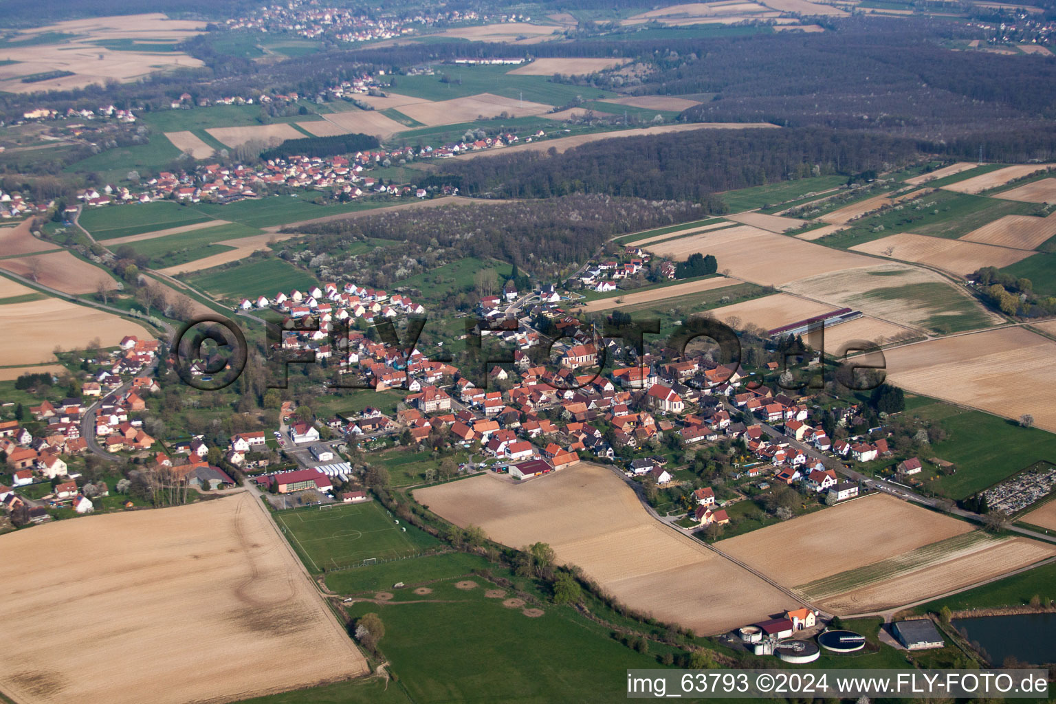 Luftaufnahme von Dorf - Ansicht am Rande von landwirtschaftlichen Feldern und Nutzflächen in Kutzenhausen in Grand Est im Bundesland Bas-Rhin, Frankreich