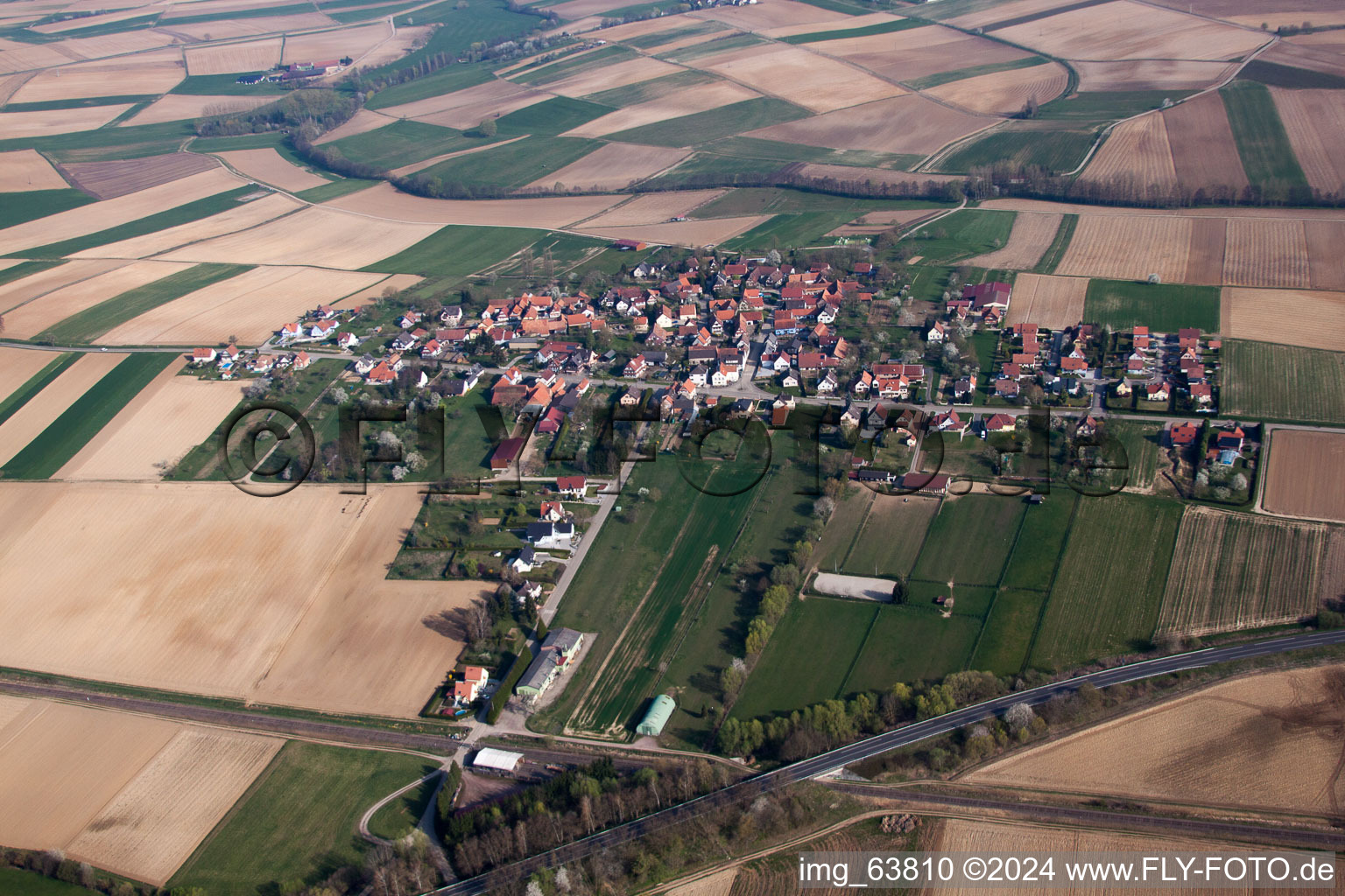 Dorf - Ansicht am Rande von landwirtschaftlichen Feldern und Nutzflächen im Ortsteil Hermerswiller in Hoffen in Grand Est im Bundesland Bas-Rhin, Frankreich
